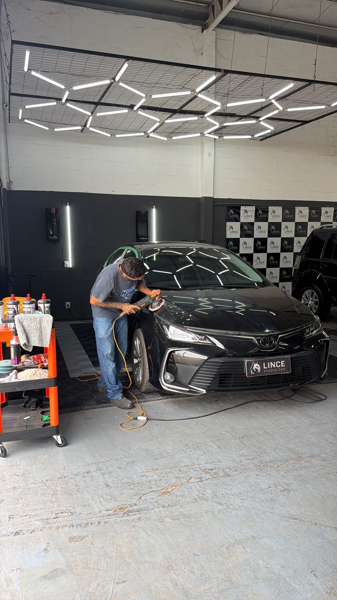 Técnico fazendo polimento em carro na Lince Studio Car, em Sinop